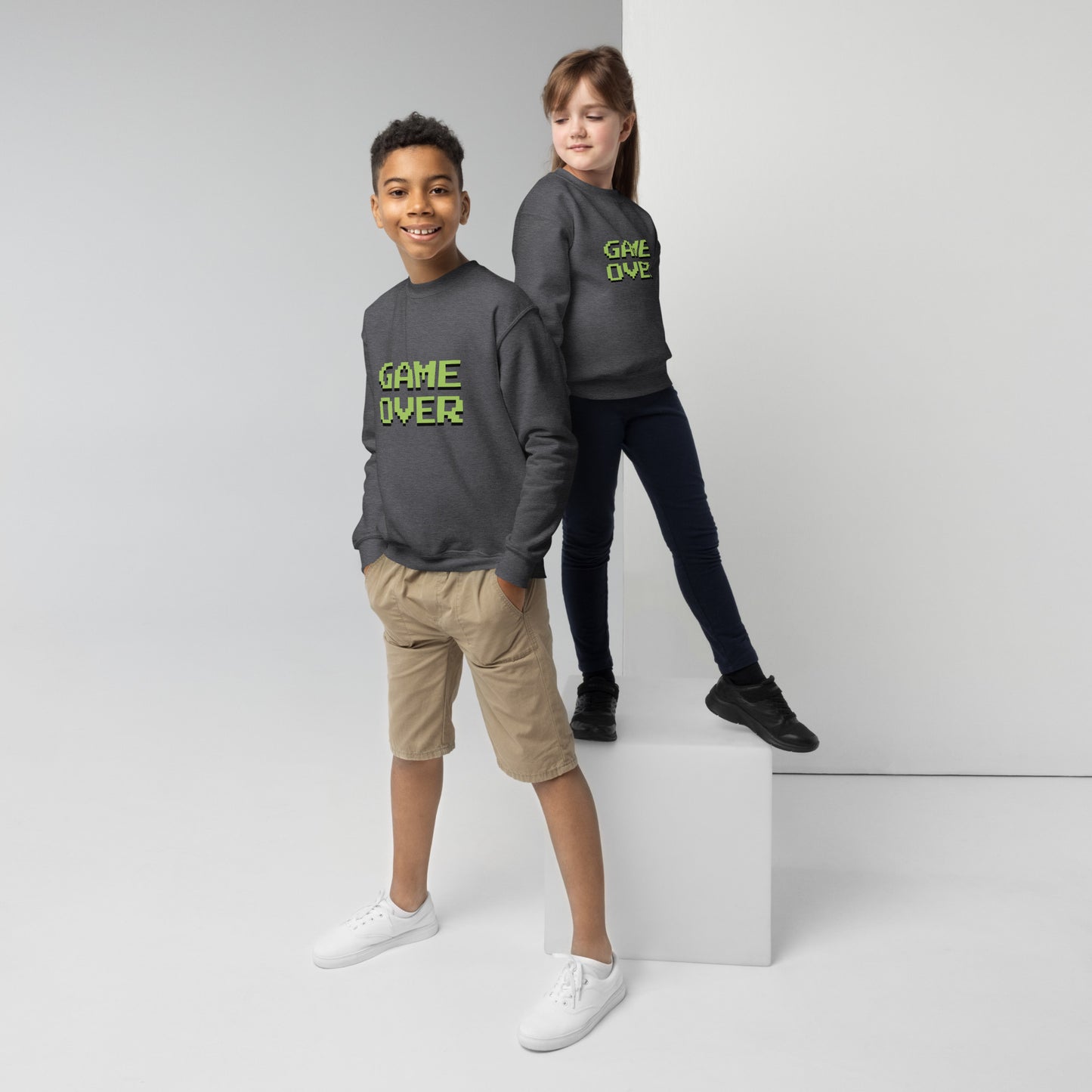 Youth with dark heather sweater with the text GAME OVER in green