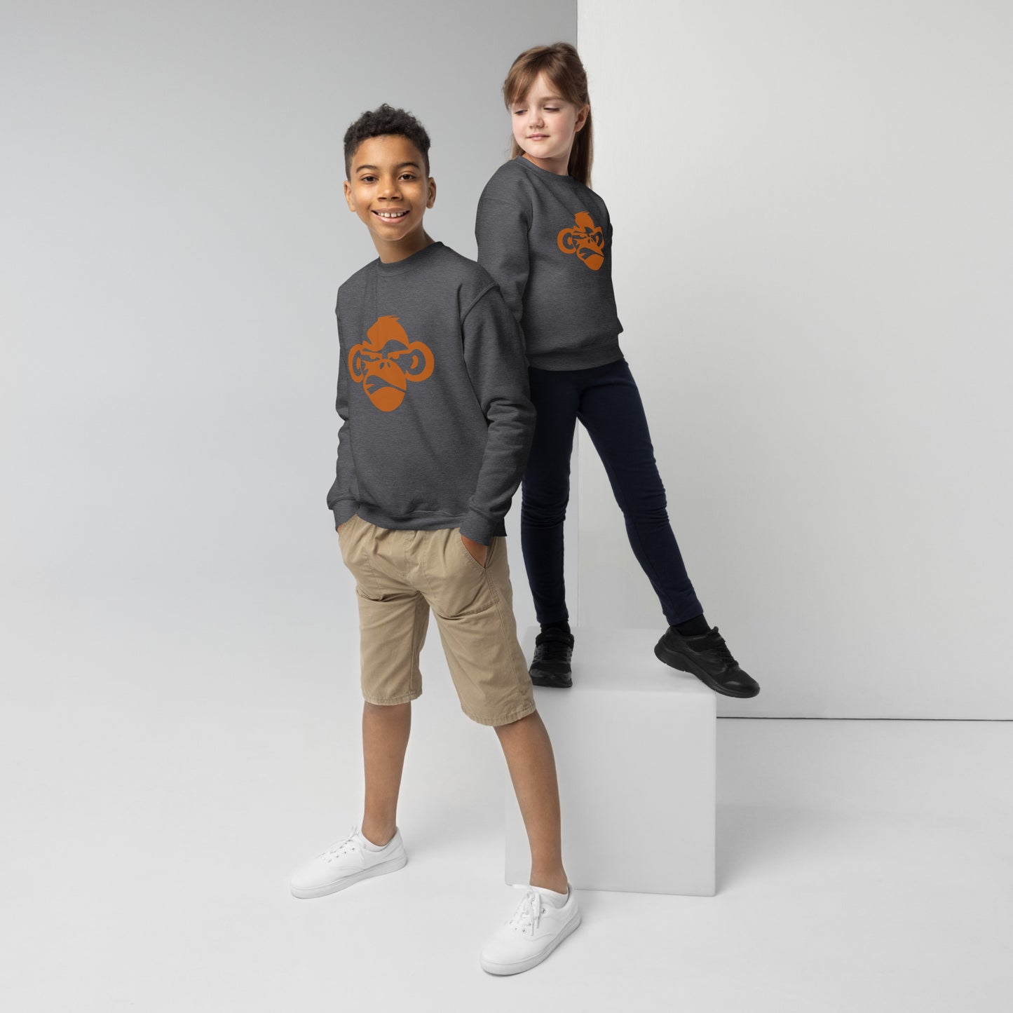 Youth with dark grey sweatshirt with a print of a head of a monkey in color brown