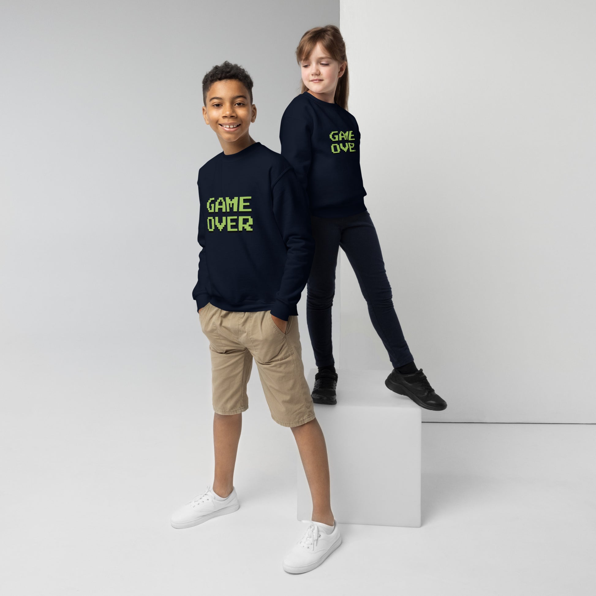 Youth with navy sweater with the text GAME OVER in green
