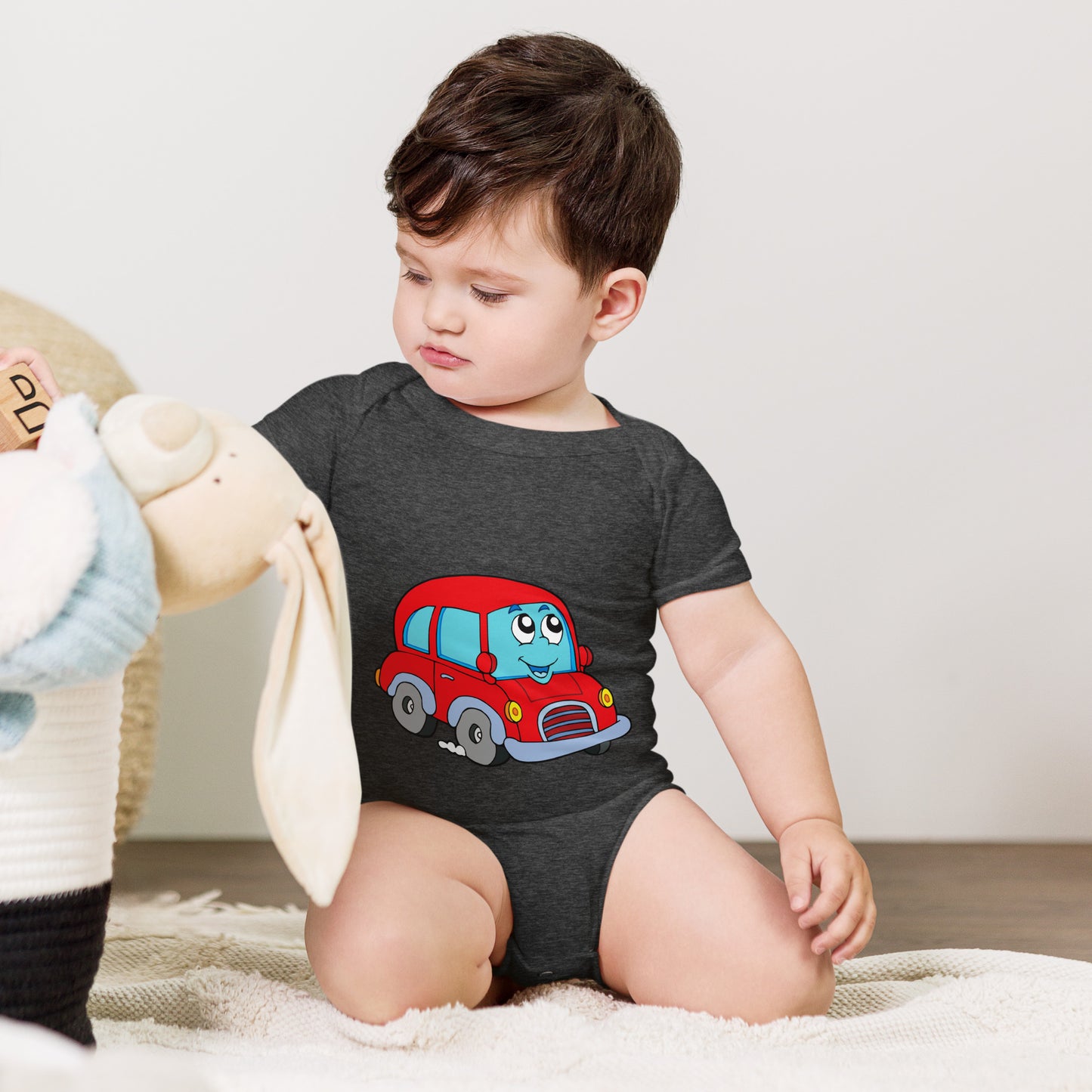 baby with dark grey short sleeve one piece with picture of a red car