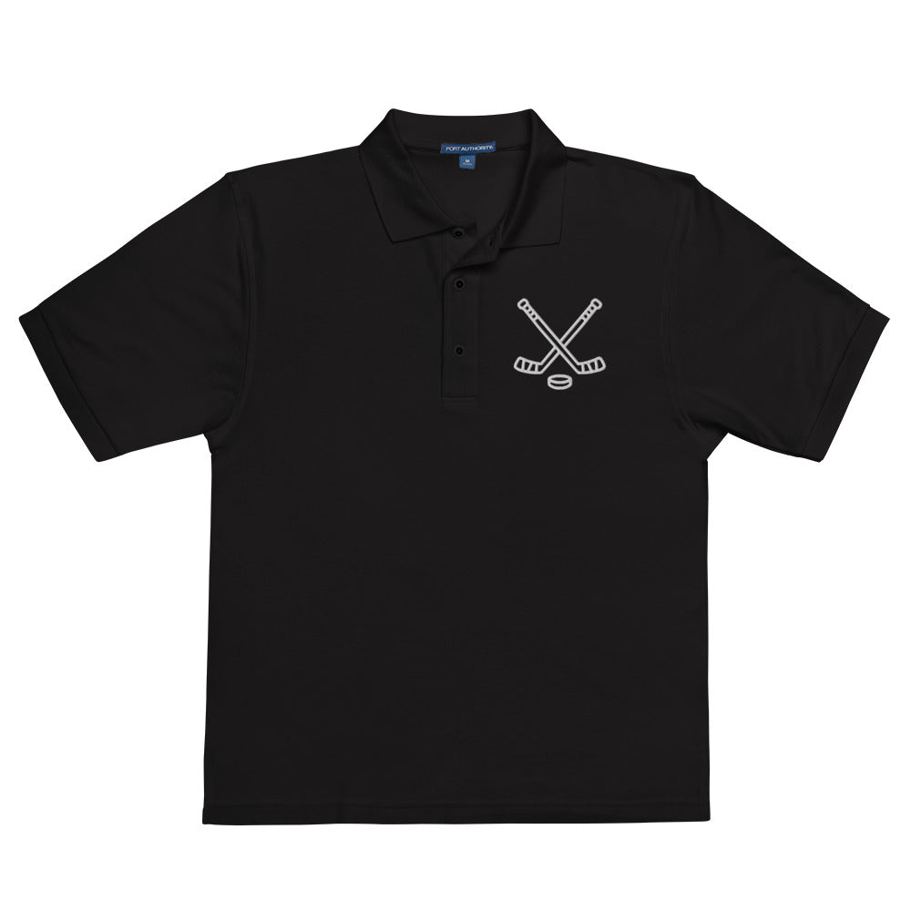 Black poloshirt with print of hockeysticks and puk